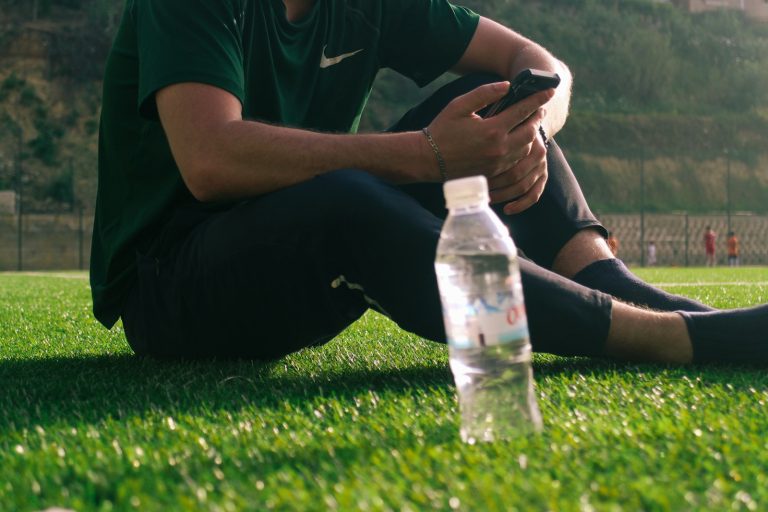 a man sitting on the grass with a bottle of water