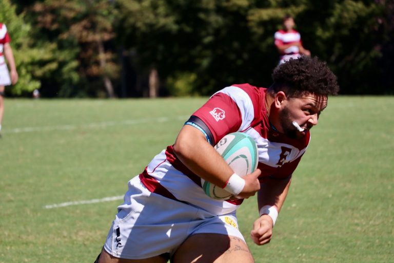 A man holding a rugby ball on a field