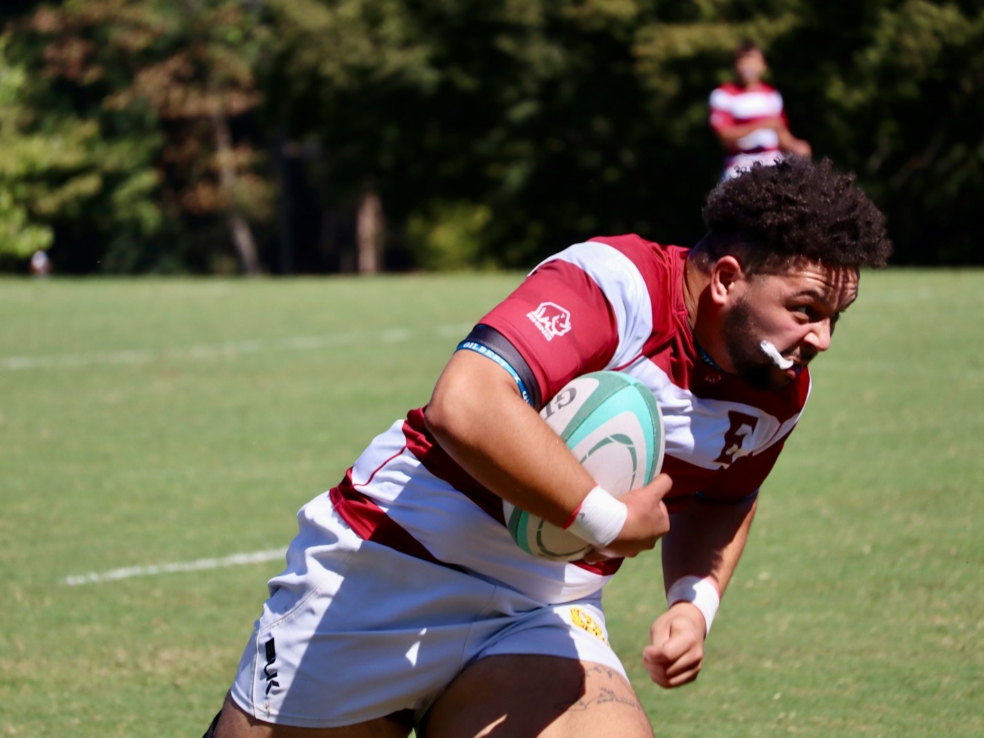 A man holding a rugby ball on a field