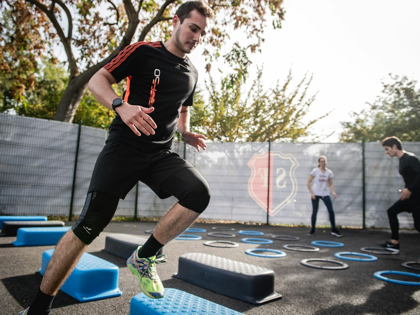 man in black crew neck t-shirt and black shorts running on blue and white trampoline