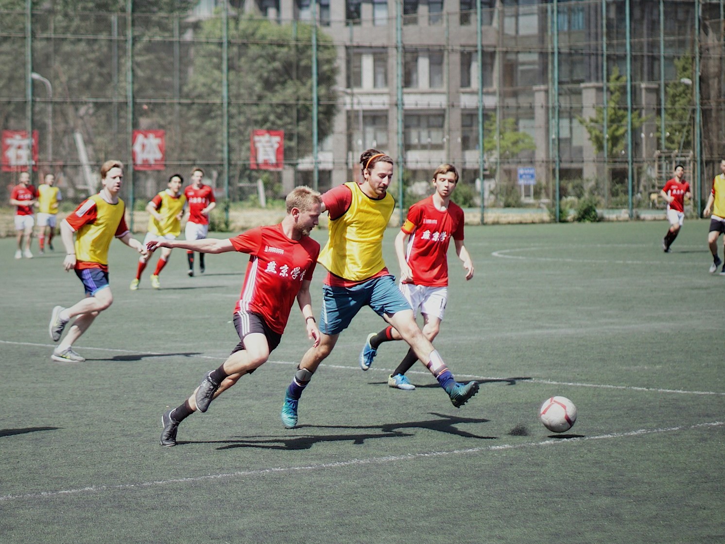 men playing soccer on field with fence